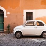 Vintage car parked in a cozy street in Trastevere, Rome, Italy, Europe.