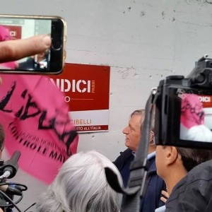 Don Ciotti osserva la targa del Maglificio